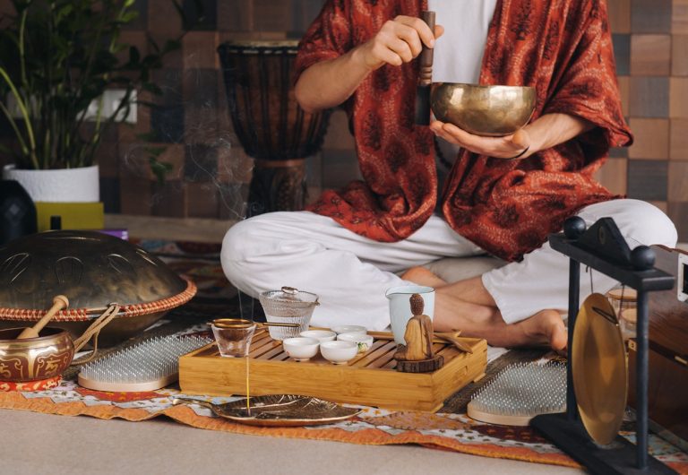 Tibetan singing bowl in the hands of a man during a tea ceremony.